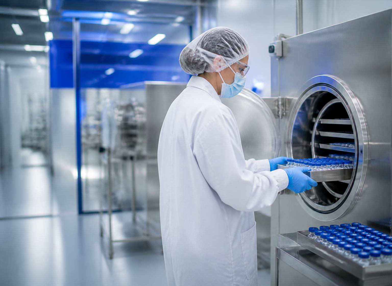 Research scientist loading research vials into a laboratory lyophilizer
